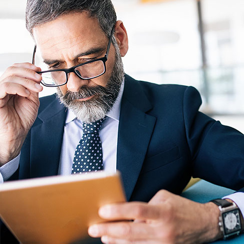 Portrait of senior businessman with digital tablet in modern office