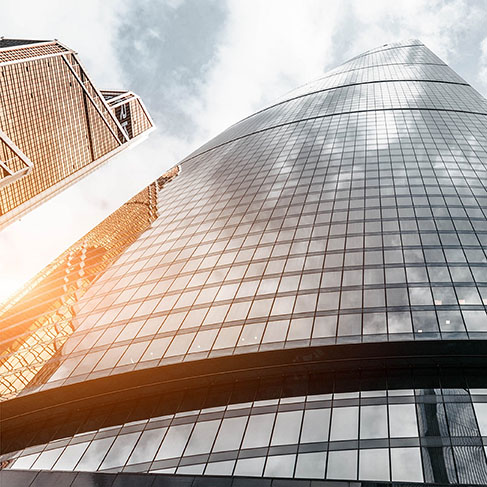 Low-angle photo of glass high-rise building with lens flare