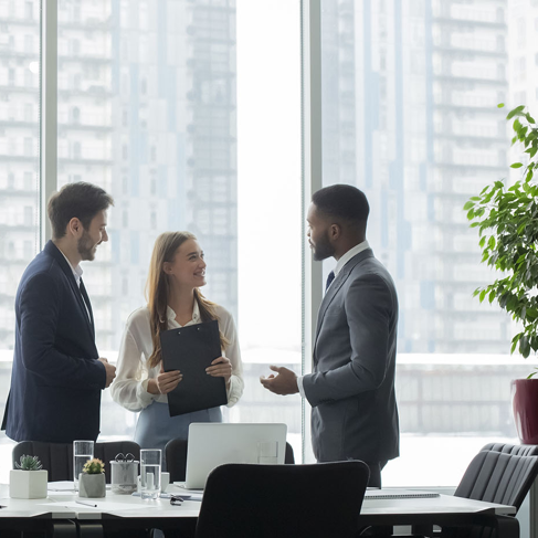 Les gens d'affaires parlant devant une fenêtre de bureau lumineux